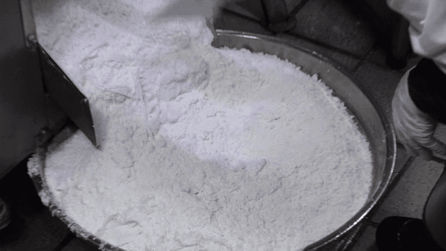 기계에서 나온 찹쌀가루를 정리하는 작업자