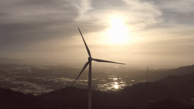 산 위의 풍력 터빈과 일몰