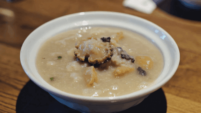 Bowl of abalone porridge on table