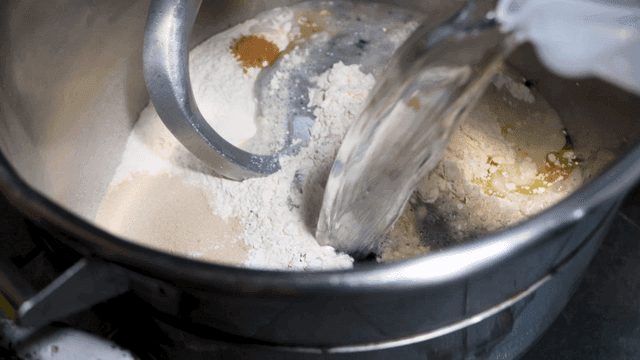 큰 믹서에 부어지는 물과 색소 반죽 재료들