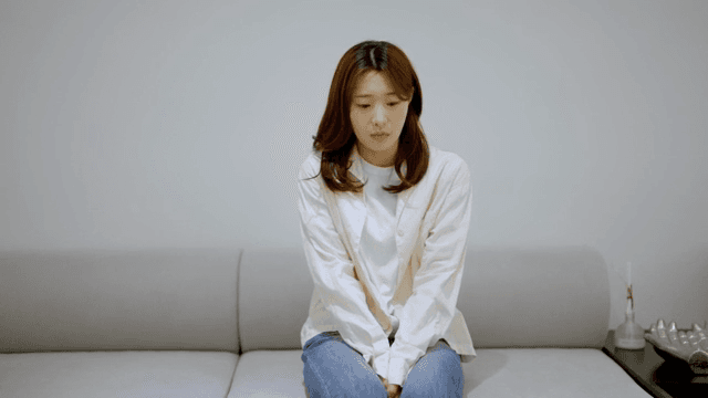 소파에 앉아 추위를 떠는 여성