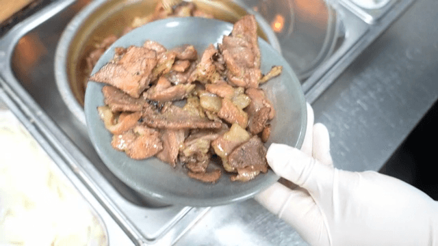 Grilled meat being served on a plate