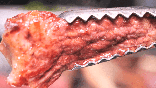 Juicy roast beef held with tongs