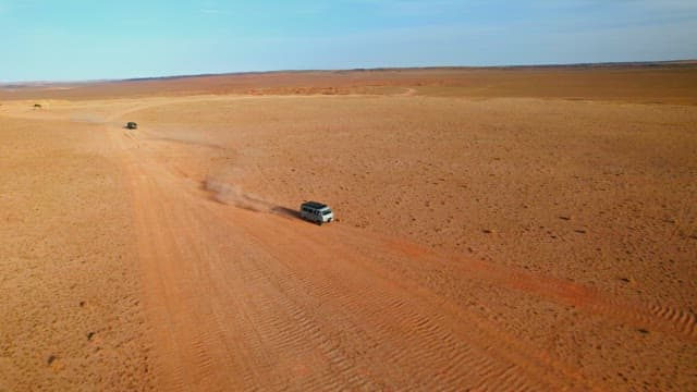 Vehicles Traversing a Vast Desert Landscape