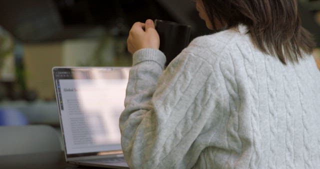 Woman Working on Laptop and Drinking Coffee