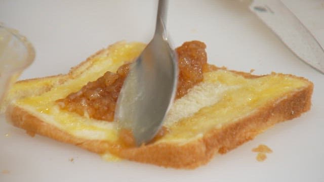 Folding toast in half with apple jam on top