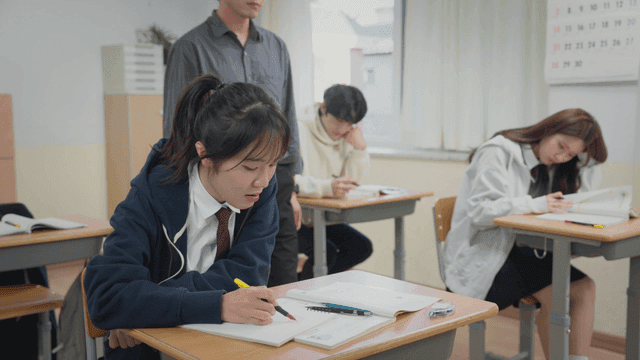 교실에서 공부하는 학생들과 질문에 답하는 선생님