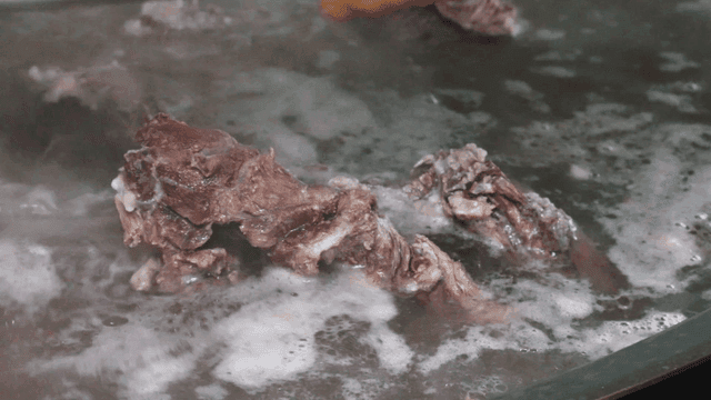 김이 나는 냄비에서 고기가 끓는 모습