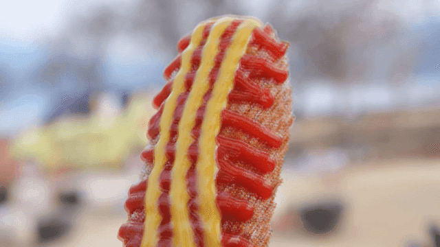 Hot dog topped with ketchup and mustard.