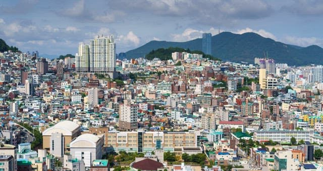 Cityscape with densely packed buildings against a mountain backdrop