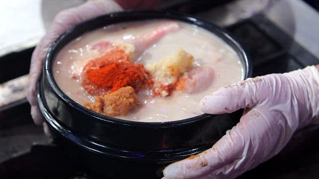 Duck soup in an earthen pot on a gas stove