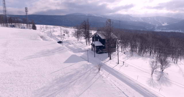 눈 덮인 산과 오두막 앞 도로