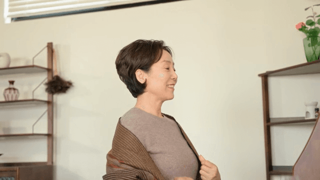 실내에서 매무새를 고치는 여성