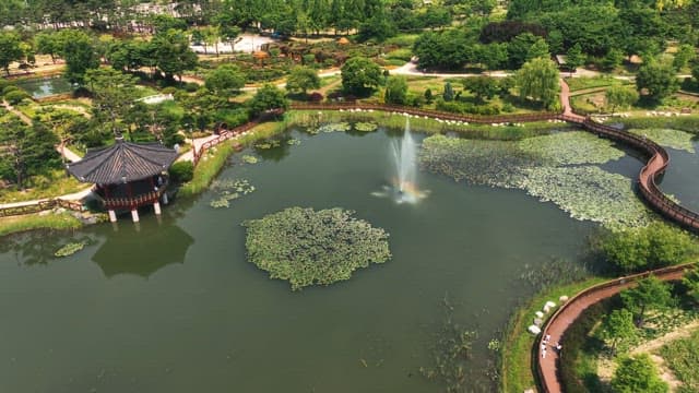 나무 산책로와 정자가 있는 경치 좋은 연못