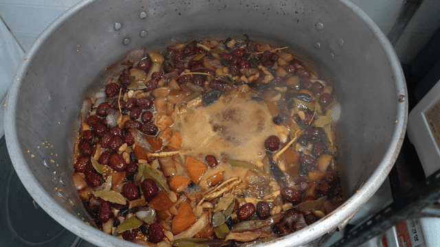 Herbal ingredients boiling in a large pot