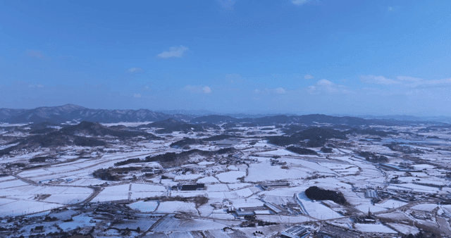 Snow-covered fields and distant mountains