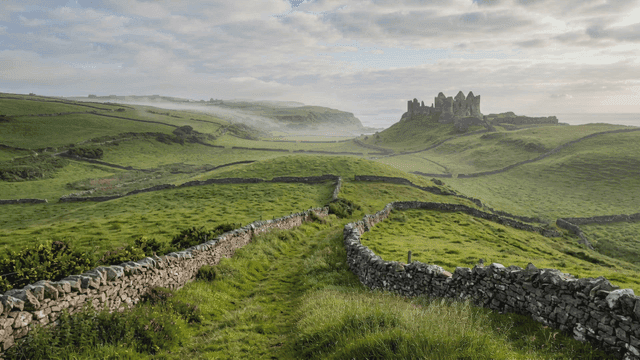 Misty meadows and castle in distance