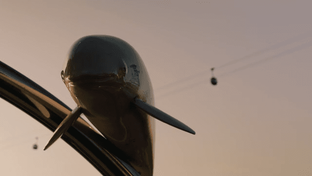 Dolphin sculpture with cable cars in the background