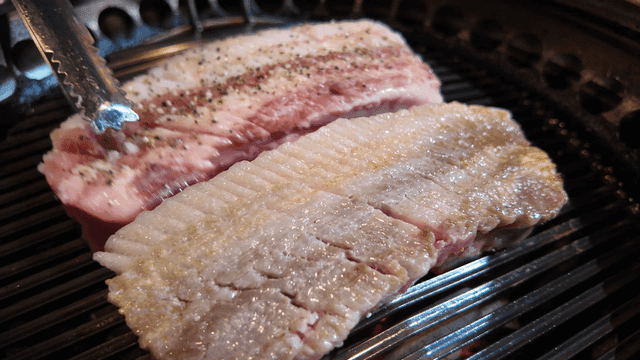 Grilling pork belly on a barbecue grill