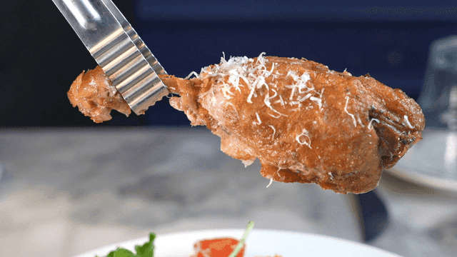 Tongs lifting duck confit
