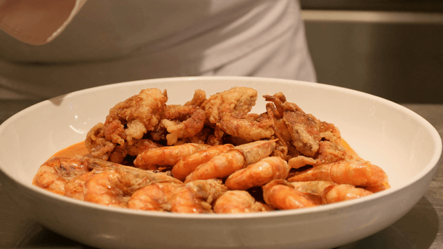Chef preparing a seafood dish with shrimp