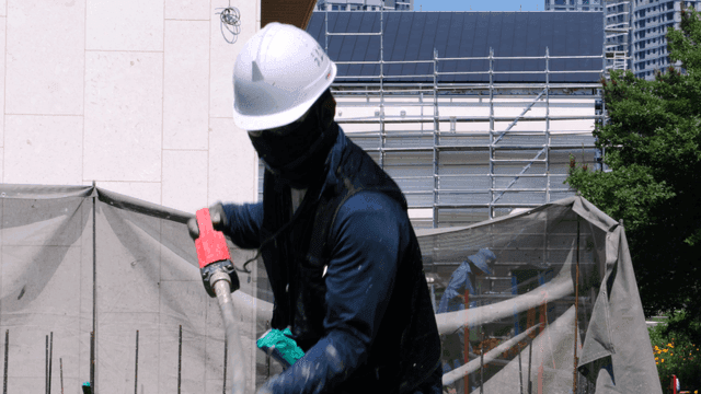 Construction worker using vibrator on concrete