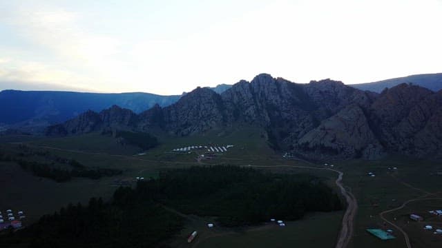 Mountain range with yurts at dusk