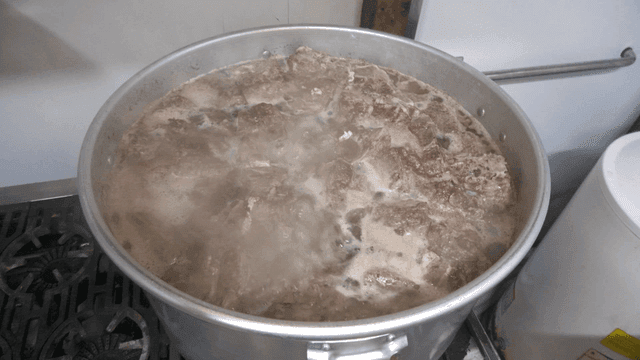 스토브 위에서 끓고 있는 큰 고기 냄비