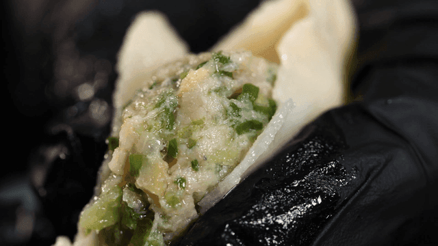 Dumpling filling pressed out with gloved hands