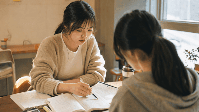 Two students studying together at a cafe