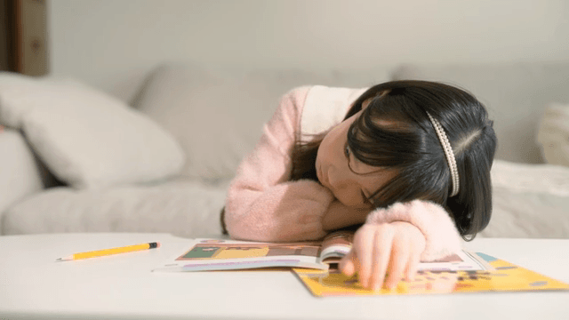 테이블에 엎드리는 어린 소녀