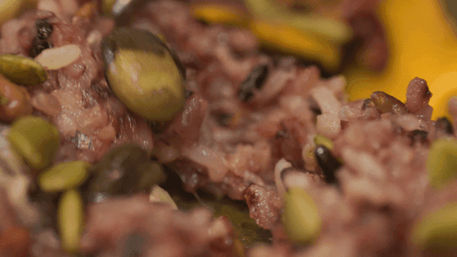 Close-up shot of sticky lotus leaf mixed grain rice tearing with chopsticks