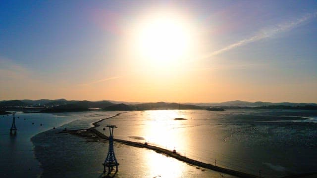 고요한 바다 위에 케이블카 타워가 있는 아름다운 노을