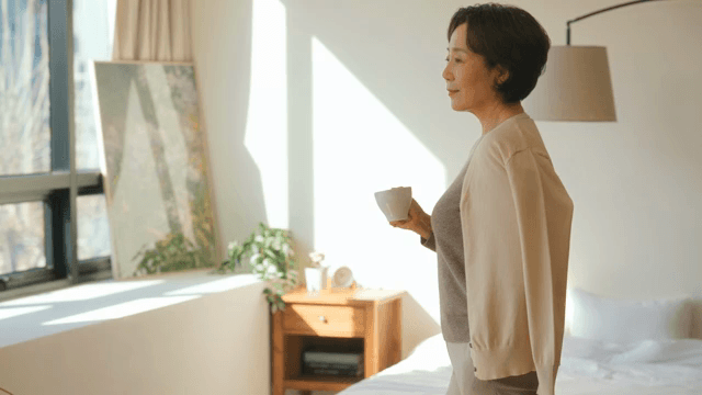 커피를 들고 창가로 가는 여성