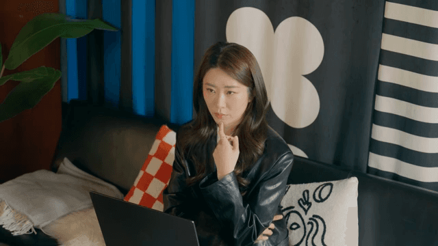 Woman lost in deep thought while working on her laptop