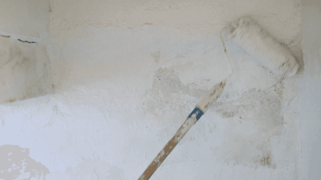 Painting a wall with a roller brush