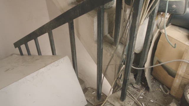 실내의 좁고 어수선한 계단을 오르는 두 여자