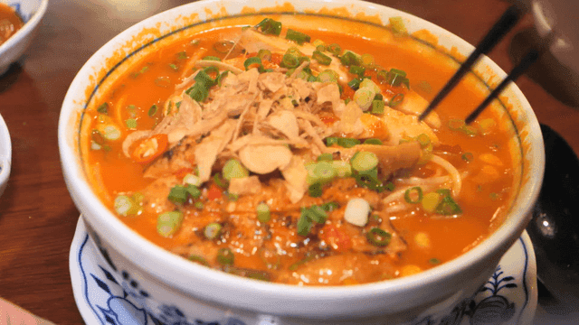 Bowl of spicy rice noodles topped with garnish