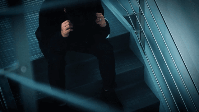 비상계단에 앉아 고되하는 남성