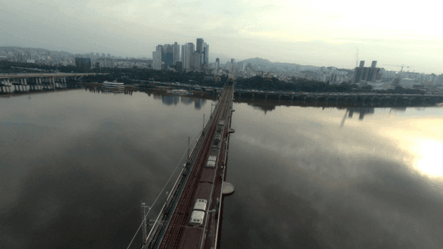 A bridge over a river with city skyline