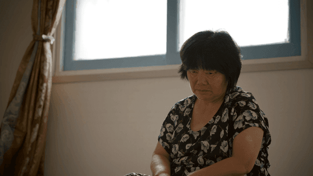 실내에서 조용히 앉아 있는 노인 여성