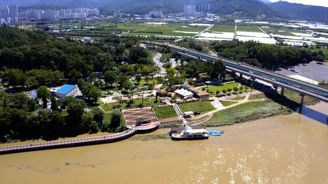 도시의 건물들을 배경으로 하고 있는 푸른 녹지대와 강변