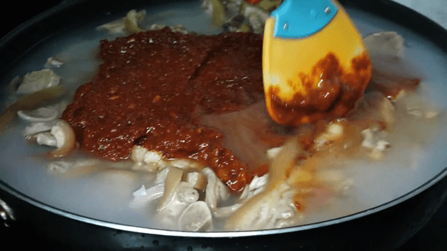 냄비에서 고추장과 족발을 섞는 장면