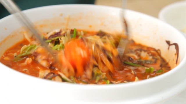 Stirring cold raw fish soup with chopsticks