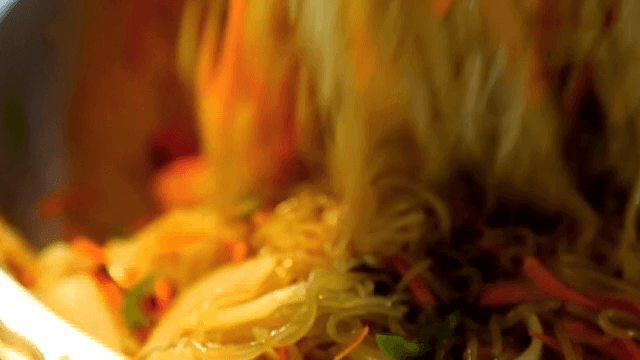 큰 대야에서 잡채를 섞는 손