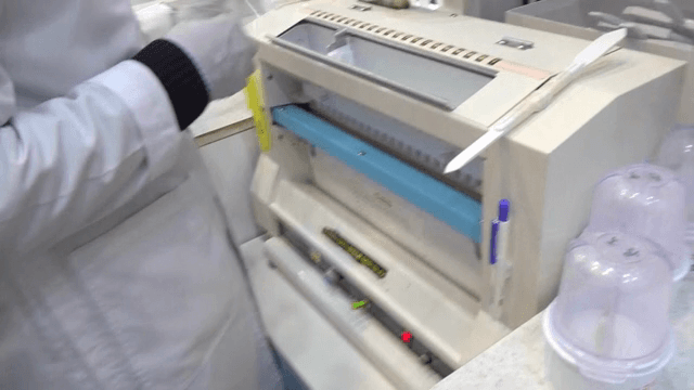 A lab technician handling test tubes