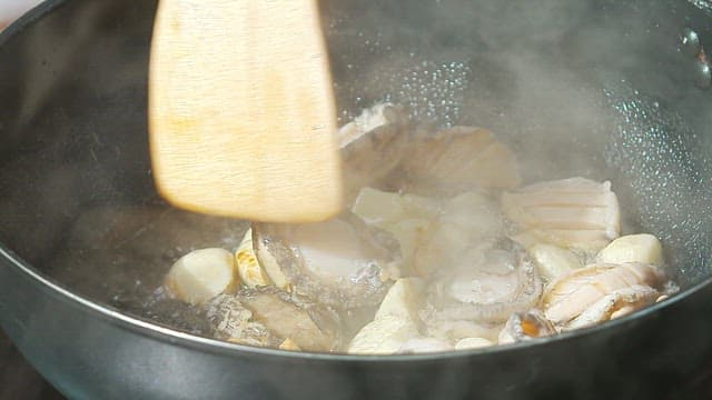 Stir-frying abalone and garlic in oil in a pan