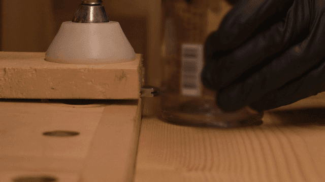 장갑 낀 손이 유리병을 다루는 모습