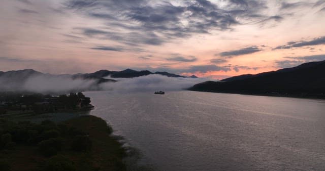 안개 낀 산과 함께한 일몰의 고요한 강