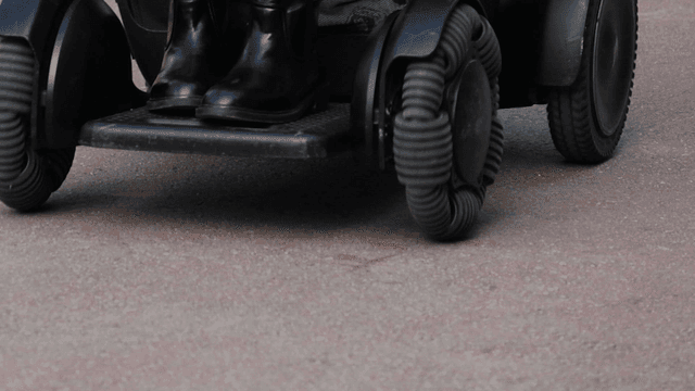 A wheelchair moving on a paved surface